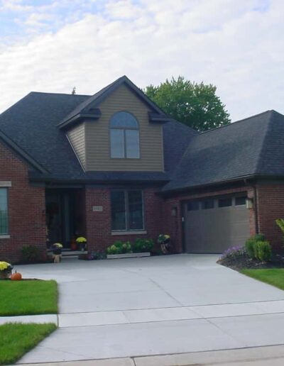 Suburban brick house with a two-car garage and landscaped front yard.