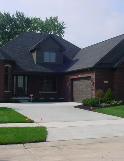 Suburban single-family home with a brick facade and a well-manicured lawn.