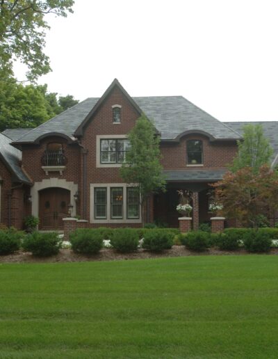 Traditional brick house with a landscaped front lawn.