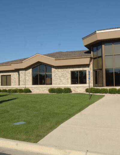 Modern dental clinic exterior with landscaped front yard and signage.