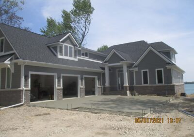 Newly constructed house with open garage and unfinished landscaping, dated june 1, 2021.